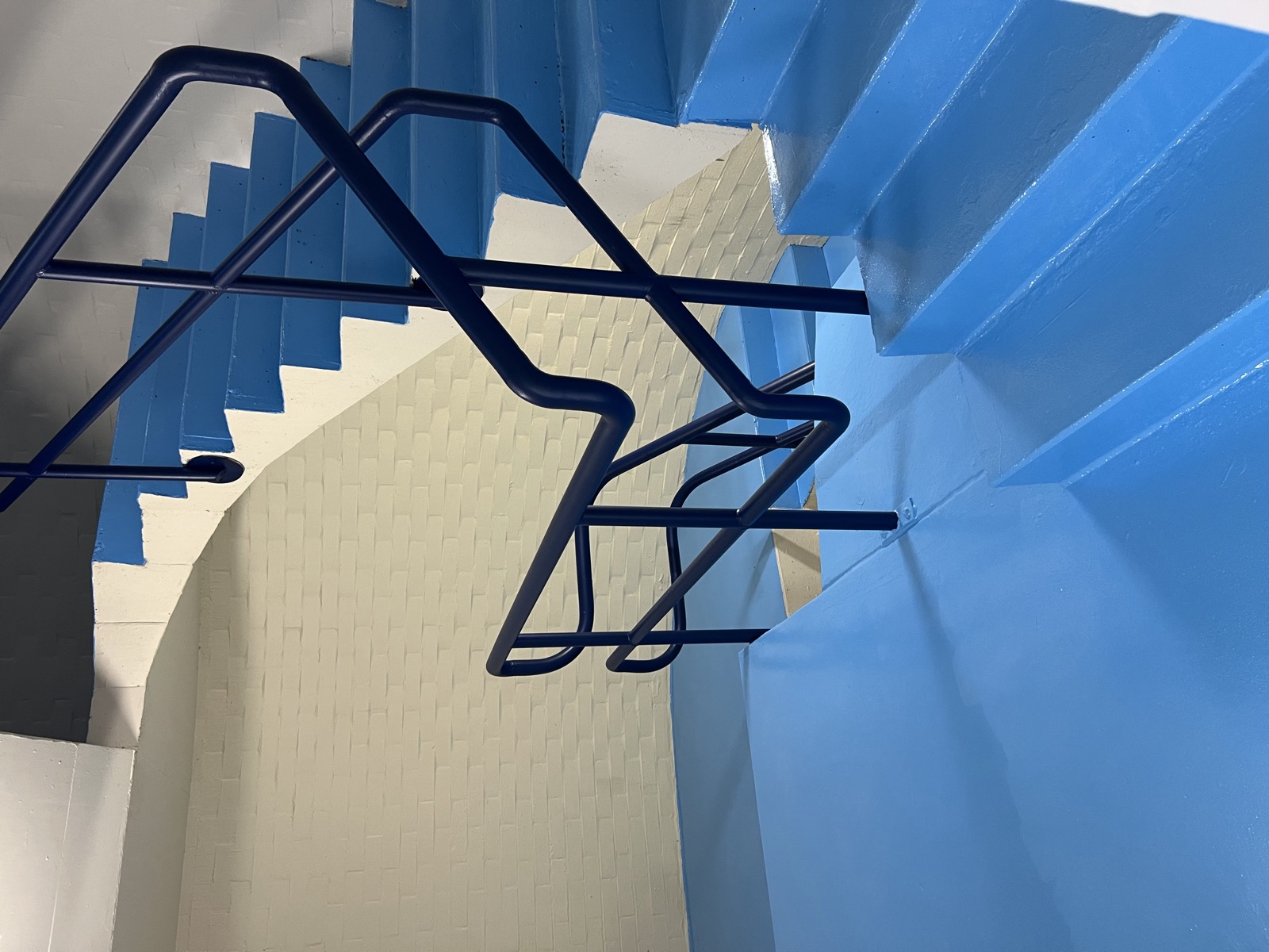 Commercial stairwell repainted blue with navy handrails by Super Painting WA